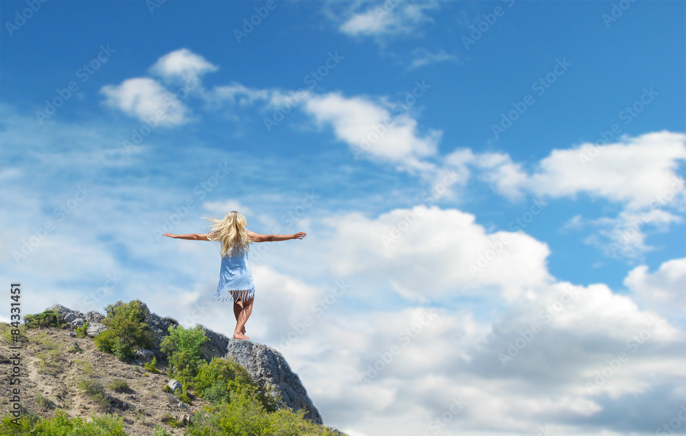 beautiful girl standing on a rock outstretched hands beautiful girl standing on a rock outstretched hands