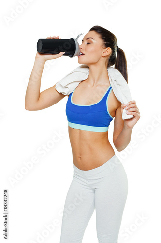 Young woman with protein shake bottle on white background © djile