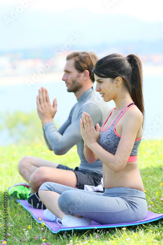 Couple doing meditation and yoga exercises in outdoor park
