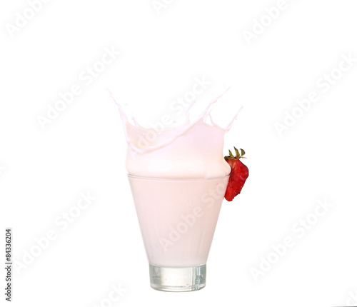 splashing strawberry into a milk glass photo