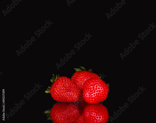 ripe red strawberries on a black background