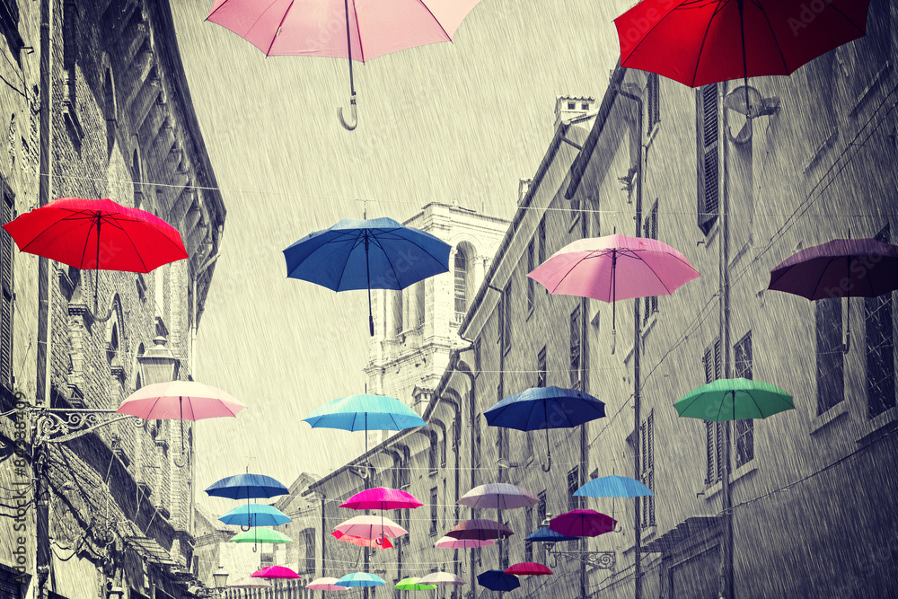 Vintage filtered umbrellas hanging above street.