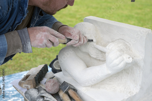 Foto Sculpture d'un joueur de flûte sur pierre blanche