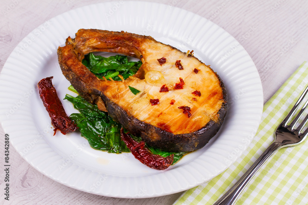Broiled fish with dried tomatoes and spinach