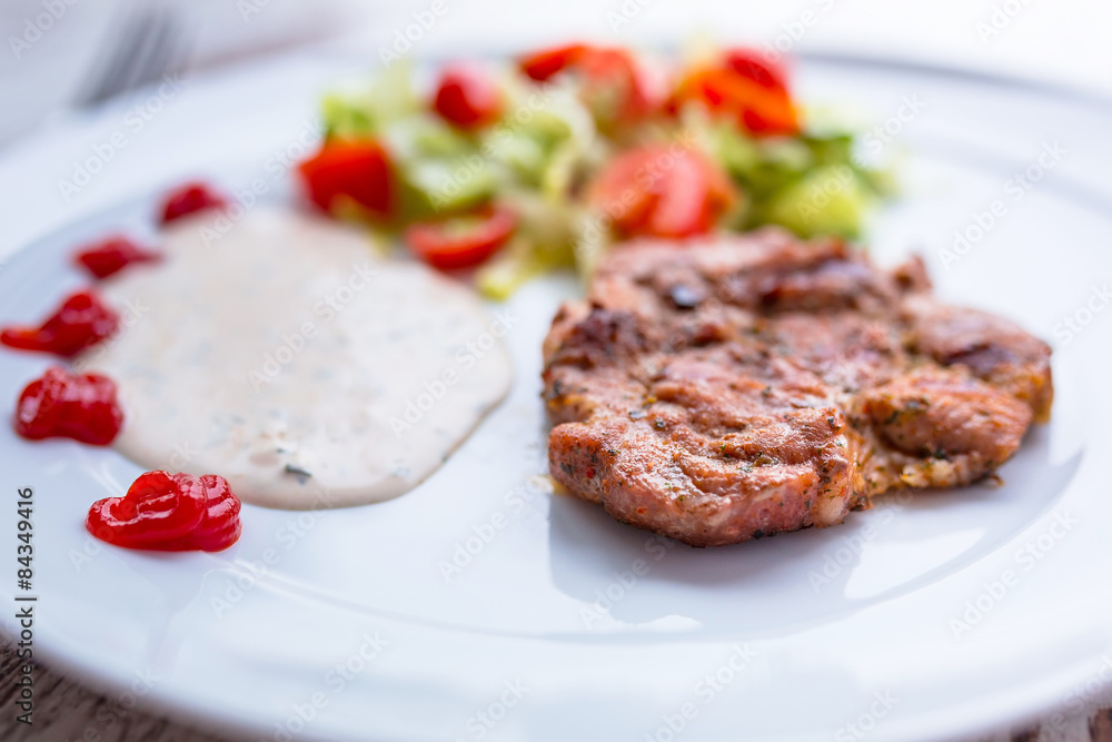 Grilled pork steak with salad on the plate Grilled pork steak with salad on the plate