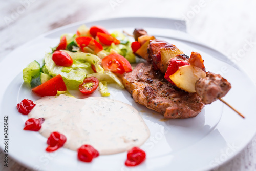 Grilled duck shashlik with salad on the plate