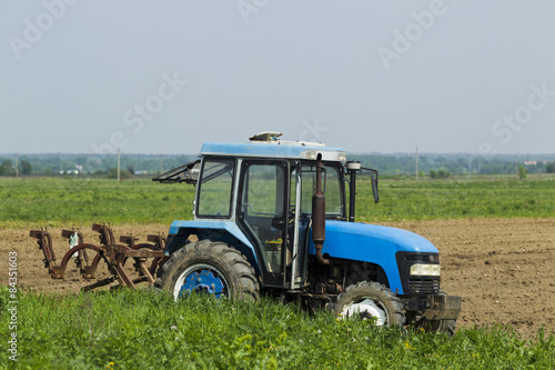 The tractor in the field on agricultural operations.