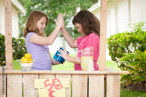 Young girls with a money bucket giving a high five photo