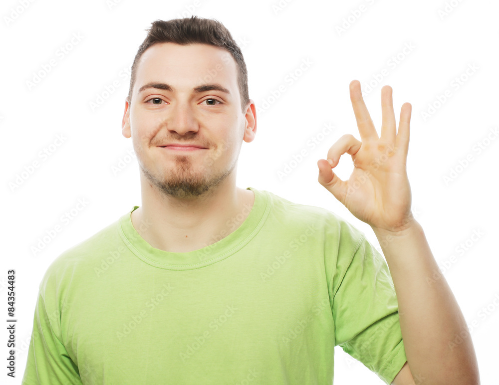 young man in green shirt showing thumbs up. young man in green shirt showing thumbs up.