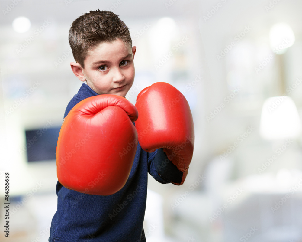 little kid fighting with red boxing gloves
