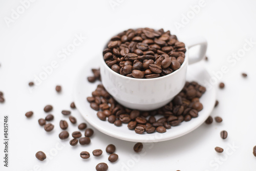 cup with coffee beans isolated on white background.