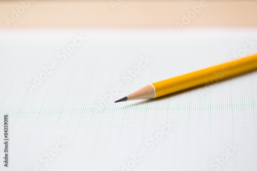 close-up yellow pencil on graph paper background