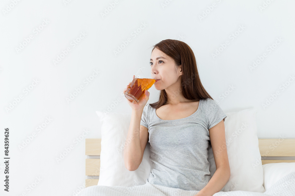 Chinese woman drink a cup of tea on bed Chinese woman drink a cup of tea on bed