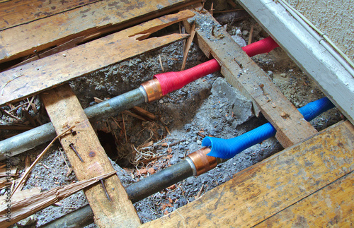 Cold and hot water pipes under broken wood floor