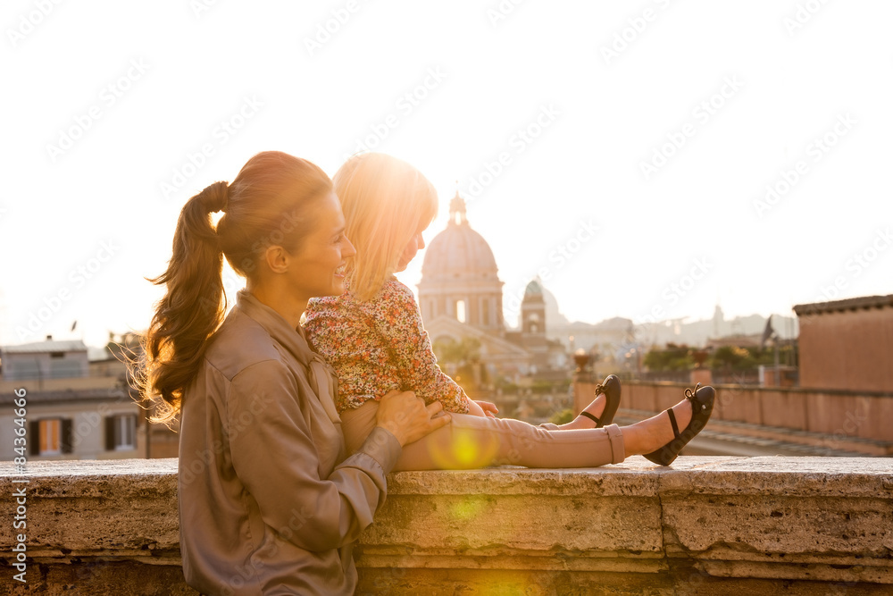 Fototapeta premium Mother and daughter in profile at sunset with St. Peter's