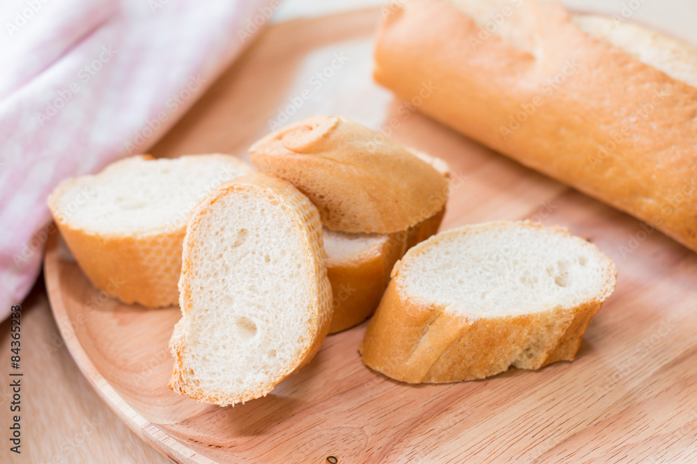 Sliced french bread baguette on wooden plate.Soft focus style Sliced french bread baguette on wooden plate.Soft focus style