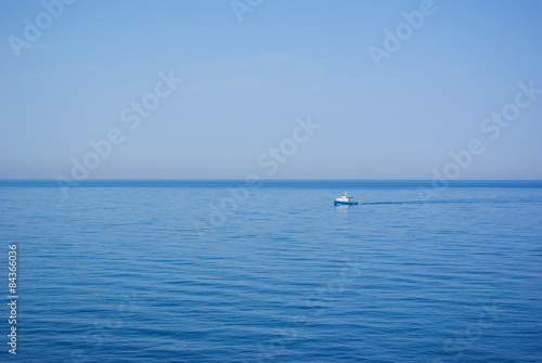 Sea water expanse with the small lonely ship