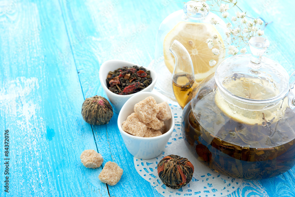 Ripe lemon, cinnamon and fruit drink in glass teapot on wooden Ripe lemon, cinnamon and fruit drink in glass teapot on wooden