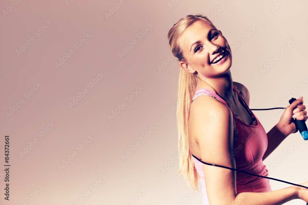 Woman smiling at camera holding a jump rope. Woman smiling at camera holding a jump rope.