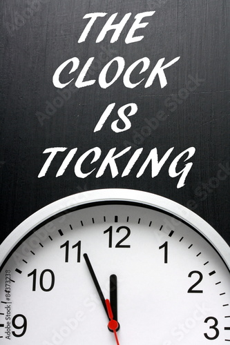 The Clock is Ticking written on a blackboard with a clock face