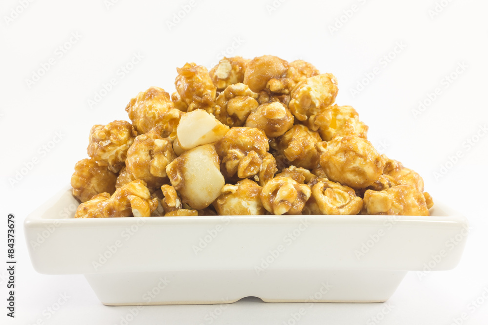 Popcorn with macadamia caramel flavour on white background. Popcorn with macadamia caramel flavour on white background.