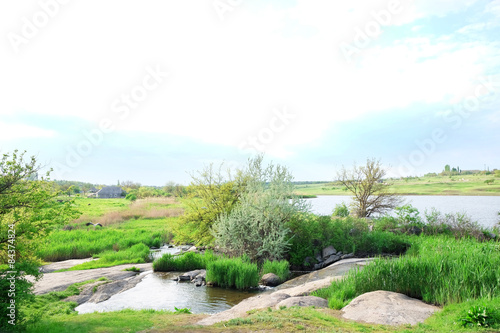 Beautiful view of countryside with ponds on blue sky background