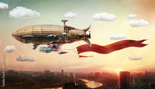 Photos Dirigible with a banner, in the sky over a city.