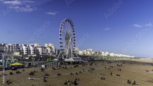 Timelipse of seaside Brighton with the Brighton wheel in a sunny spring afternoon photo