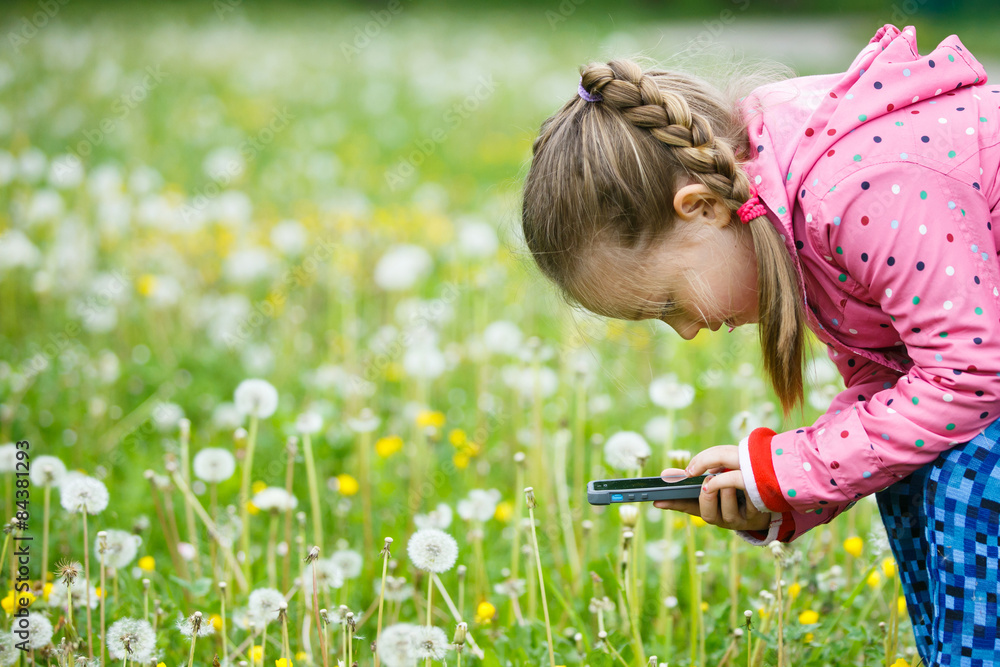 Little girl exploring nature with her smartphone