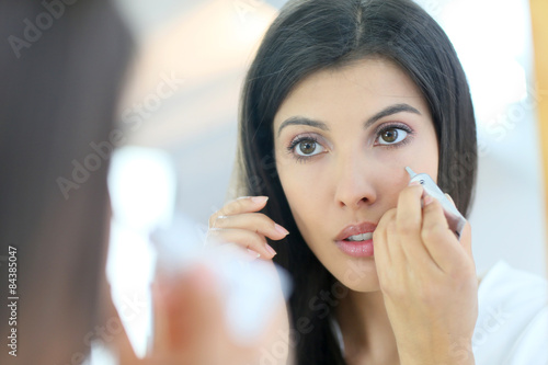 Portrait of beautiful woman using cosmetics