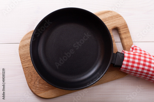 Empty pan on wooden deck table with tablecloth 