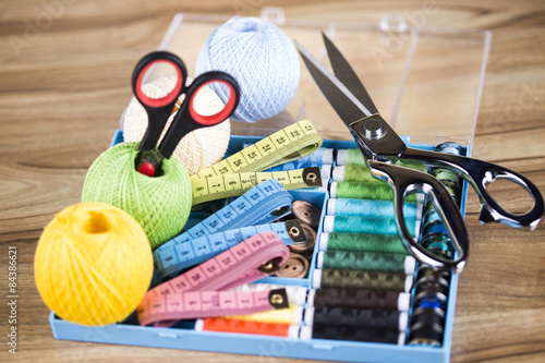 Sewing kit. Colored thread, pins, buttons, ribbons, safety pin.