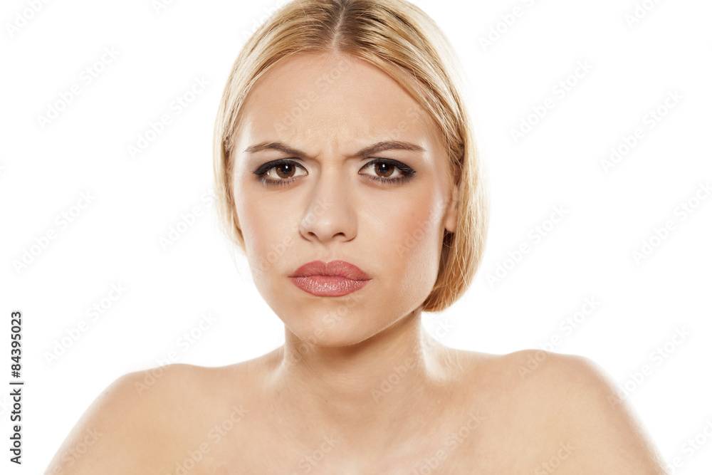 scowling young woman on a white background scowling young woman on a white background