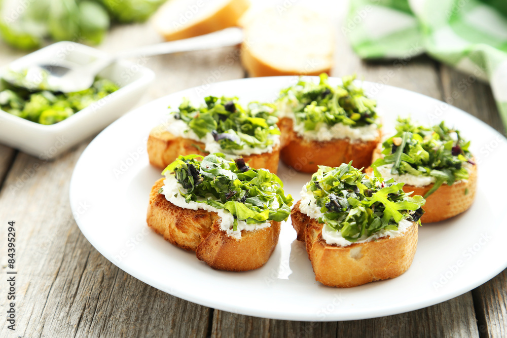 Tasty fresh bruschetta on plate on grey wooden background Tasty fresh bruschetta on plate on grey wooden background