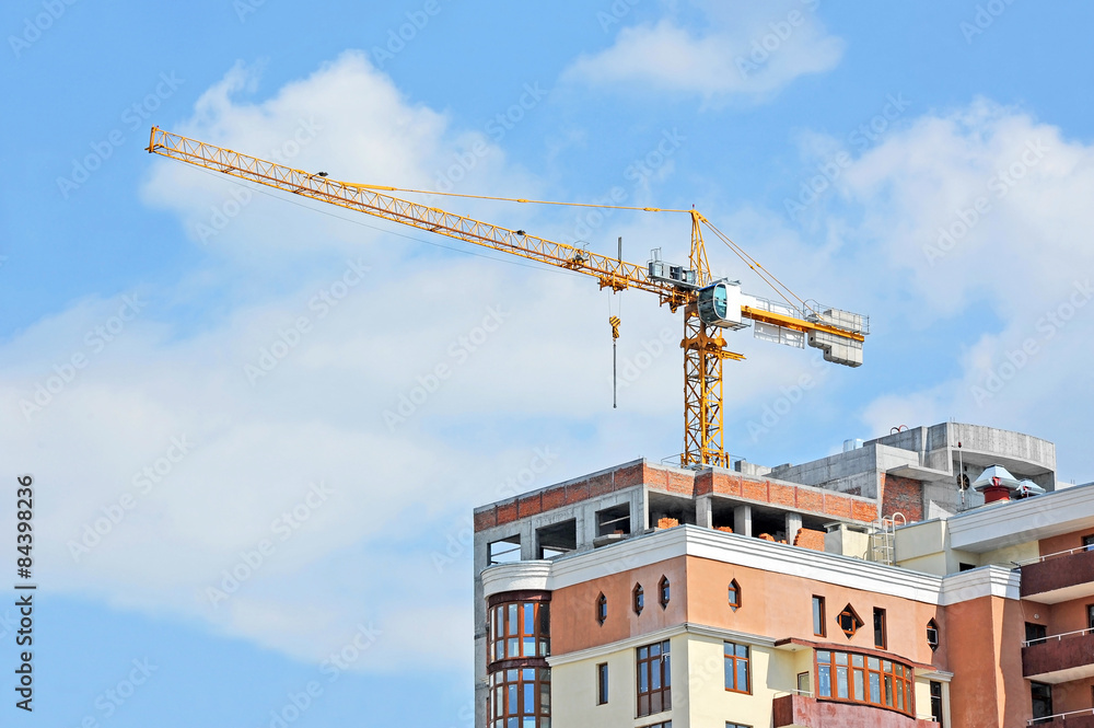 Crane and building construction site against blue sky