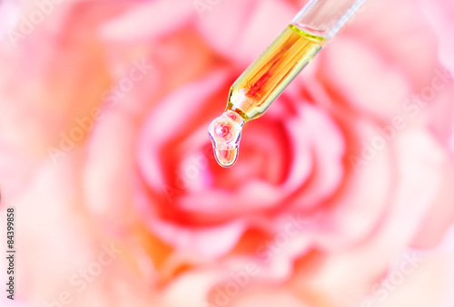 Rose essential oil. Water dropping from pipette. 
