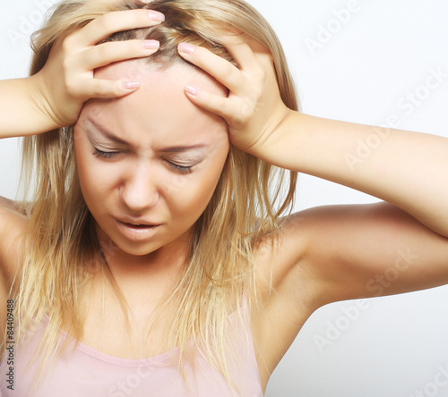 blond woman with a headache holding head
