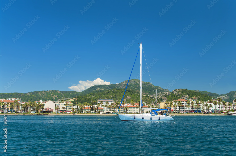white yacht near beach with mountains at back