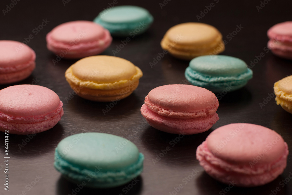 Сolorful tasty macaroons cookies on black table background Сolorful tasty macaroons cookies on black table background