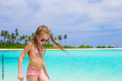 Adorable happy little girl have fun at shallow water on beach © travnikovstudio