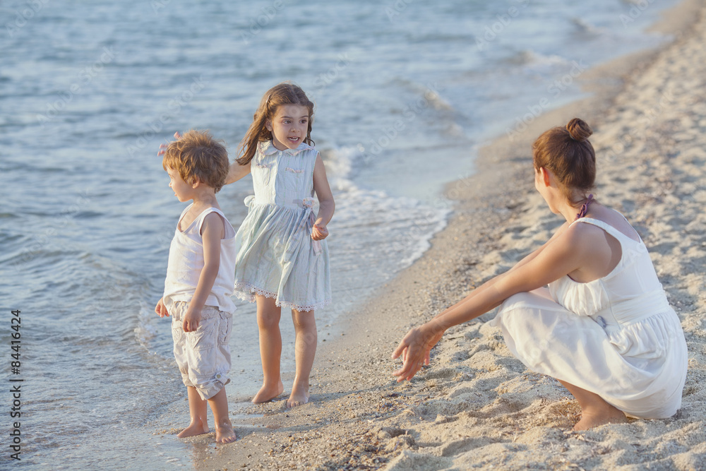 Kids playng on the beach with their mother Kids playng on the beach with their mother