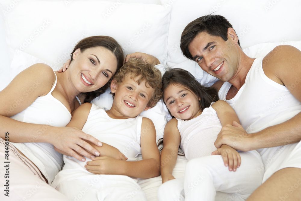 Overhead View Of Young Family Lying In Bed