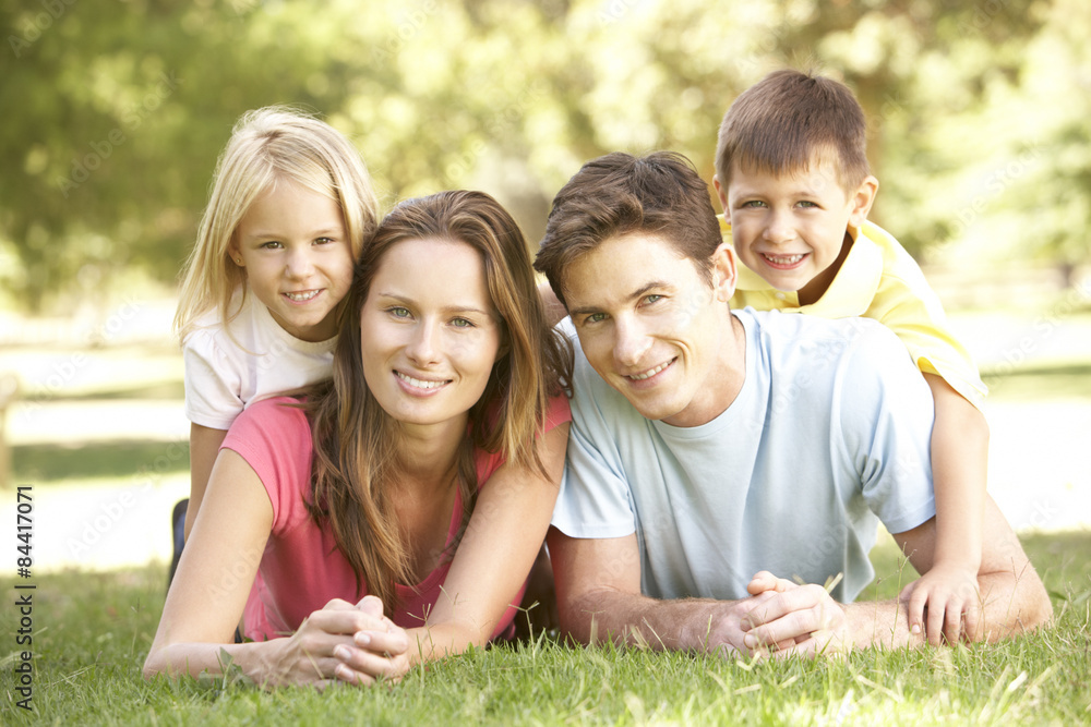 Young Family Relaxing Together In Park Young Family Relaxing Together In Park