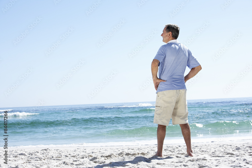Senior Man On Holiday Standing On Sandy Beach Senior Man On Holiday Standing On Sandy Beach
