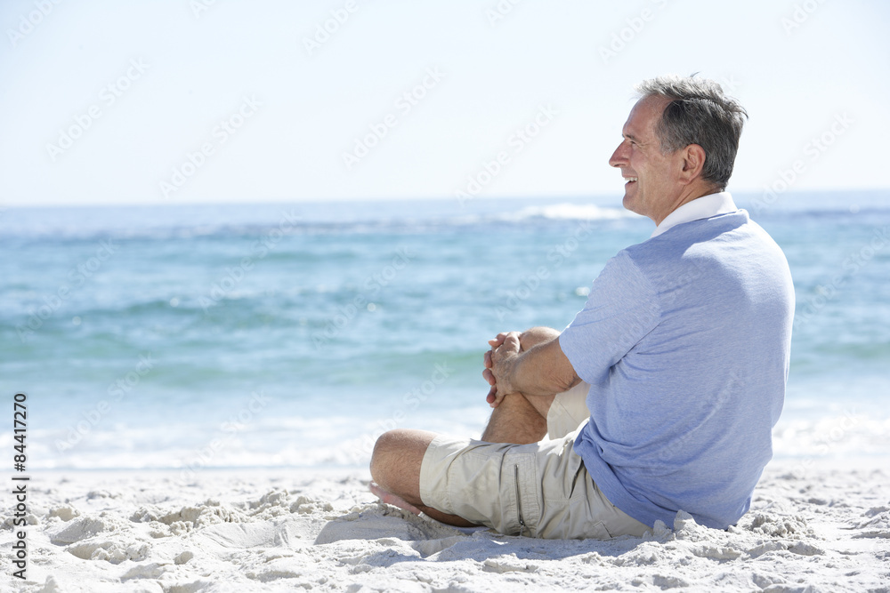 Senior Man On Holiday Sitting On Sandy Beach Senior Man On Holiday Sitting On Sandy Beach