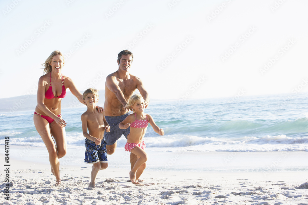 Young Family Running Along Beach on Holiday