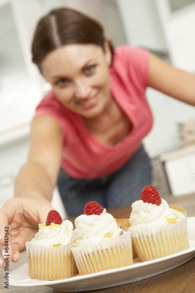 Woman Eating Cakes In Kitchen