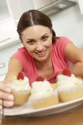 Woman Eating Cakes In Kitchen