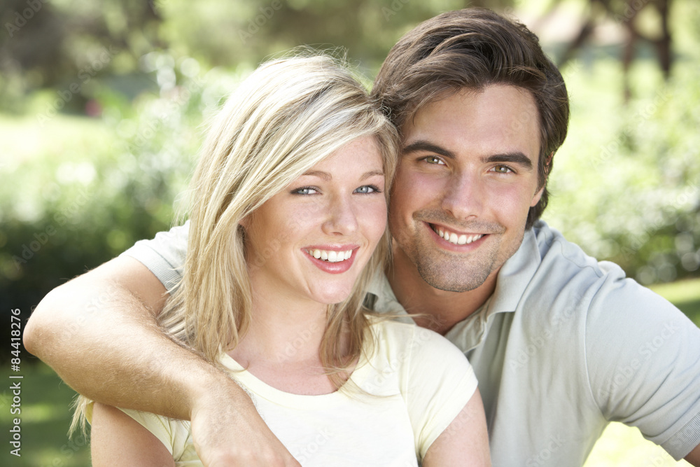 Portrait Of Young Couple Relaxing In Countryside Portrait Of Young Couple Relaxing In Countryside
