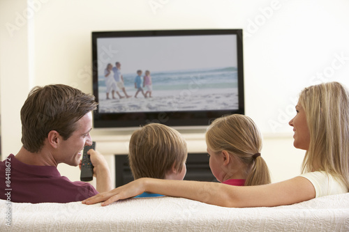 Family Watching Widescreen TV At Home